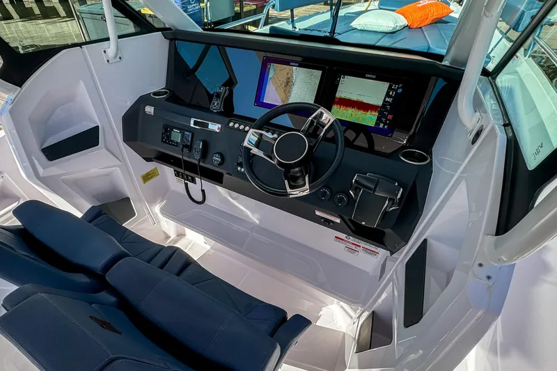 Slide: The Image of 2026 Axopar 29 Sun Top boat cockpit with modern navigation displays and steering wheel. - 15