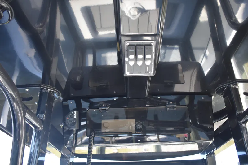 Slide: The Image of Interior view of 2025 NauticStar 251 Hybrid boat's control panel and switches. - 36