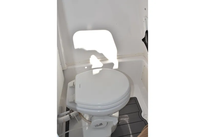 Slide: The Image of 2025 NauticStar 251 Hybrid boat interior with a compact marine toilet. - 39