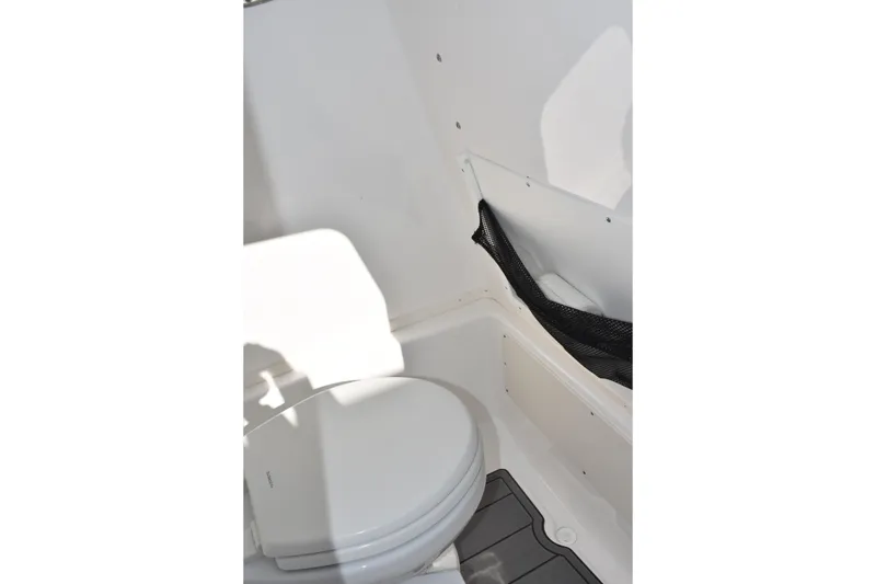Slide: The Image of 2025 NauticStar 251 Hybrid boat interior with compact marine toilet. - 40