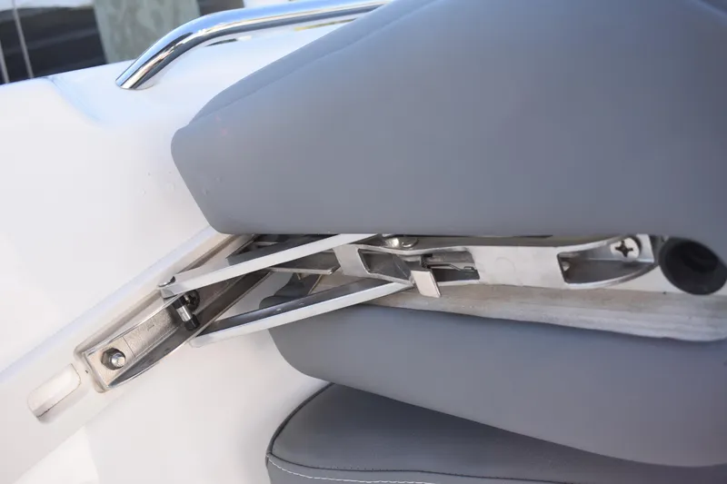 Slide: The Image of 2025 NauticStar 251 Hybrid boat seat hinge detail with gray upholstery. - 45