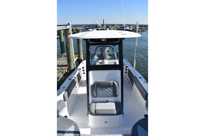 Slide: The Image of 2025 NauticStar 251 Hybrid boat interior with seating, docked by the water. - 53