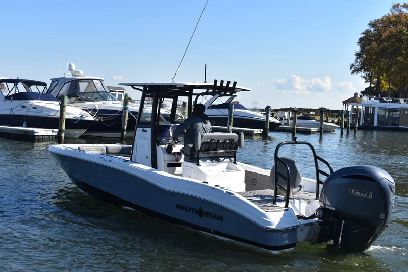 Slide: The Image of 2025 NauticStar 251 Hybrid boat cruising in a marina with Yamaha engine. - 69