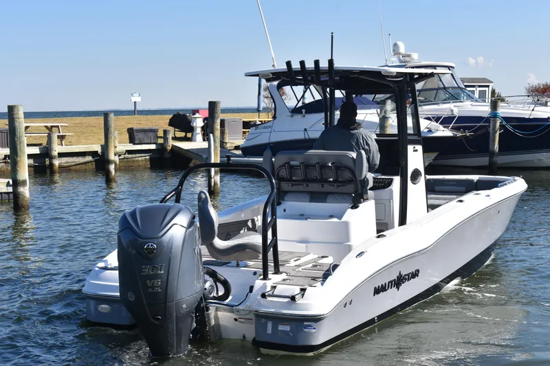 Slide: The Image of 2025 NauticStar 251 Hybrid boat docked, featuring a powerful outboard motor. - 74