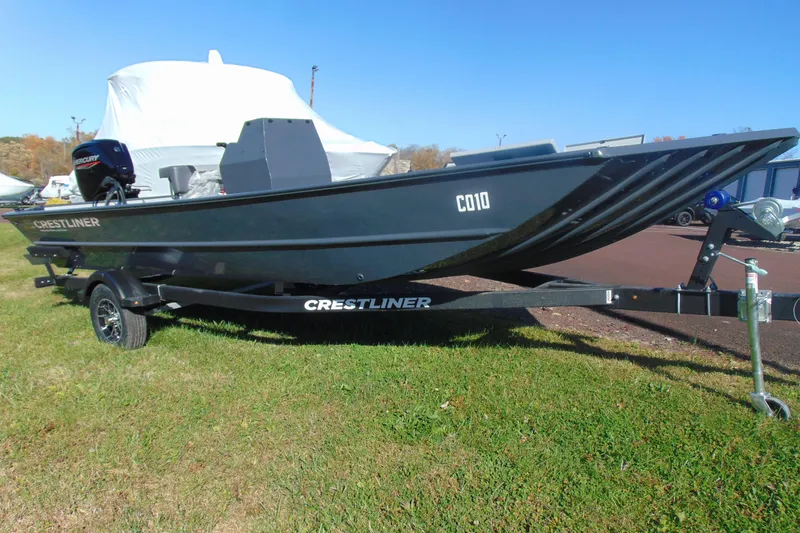 The Image of 2026 Crestliner 2070 Retriever CC boat on trailer, parked on grass. - 1