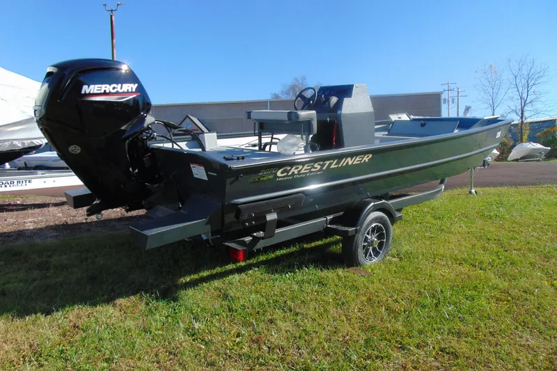 Slide: The Image of 2026 Crestliner 2070 Retriever CC boat with Mercury engine on trailer, parked on grass. - 2
