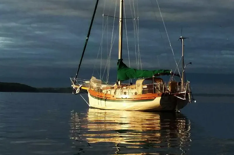 The Image of 1985 Sam L. Morse Bristol Channel Cutter 28 sailboat on calm water at sunset. - 0