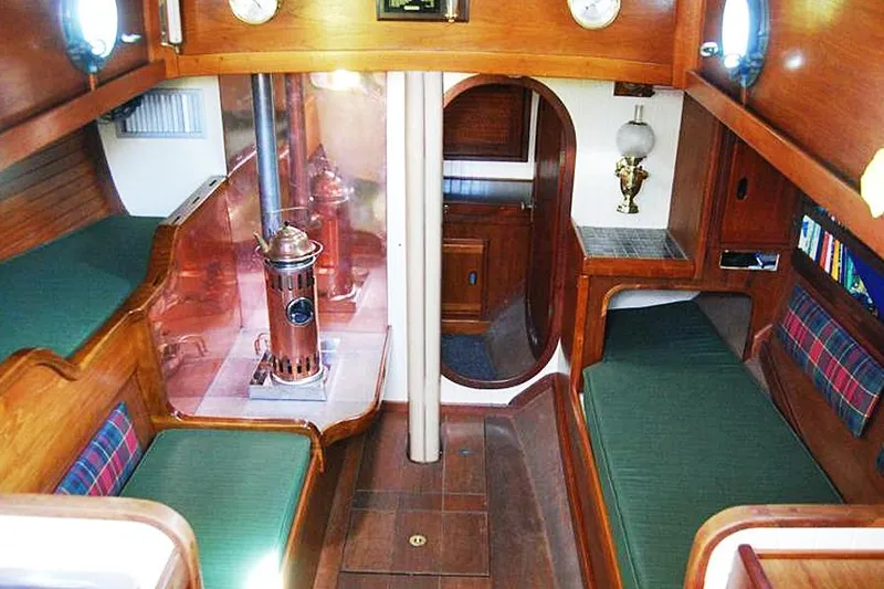 Slide: The Image of Interior of a 1985 Sam L. Morse Bristol Channel Cutter 28, featuring cozy wooden furnishings. - 4