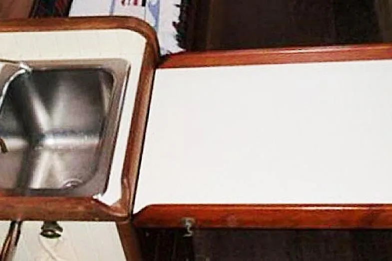 Slide: The Image of Interior of 1985 Sam L. Morse Bristol Channel Cutter 28, featuring a compact sink and countertop. - 6