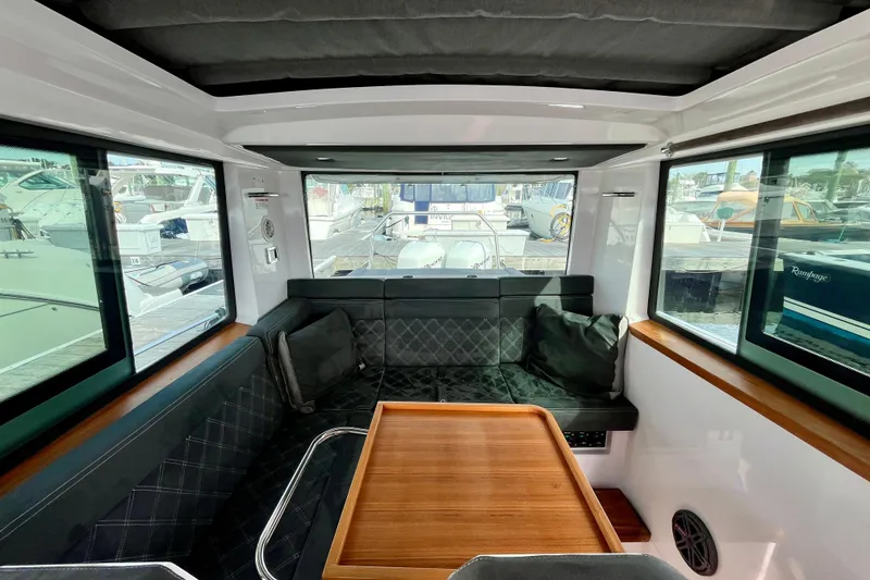 Slide: The Image of Interior of 2018 Axopar 37 Sport Cabin R with seating and wooden table. - 16