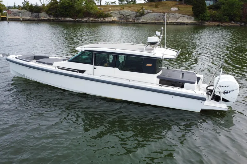Slide: The Image of 2018 Axopar 37 Sport Cabin R boat on calm water, side view. - 2