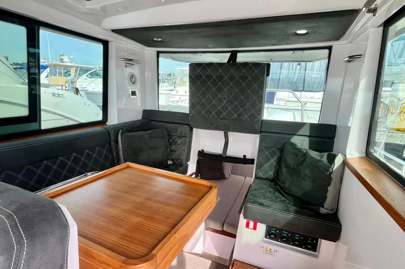 Slide: The Image of Interior of 2018 Axopar 37 Sport Cabin R with seating and wooden table. - 20
