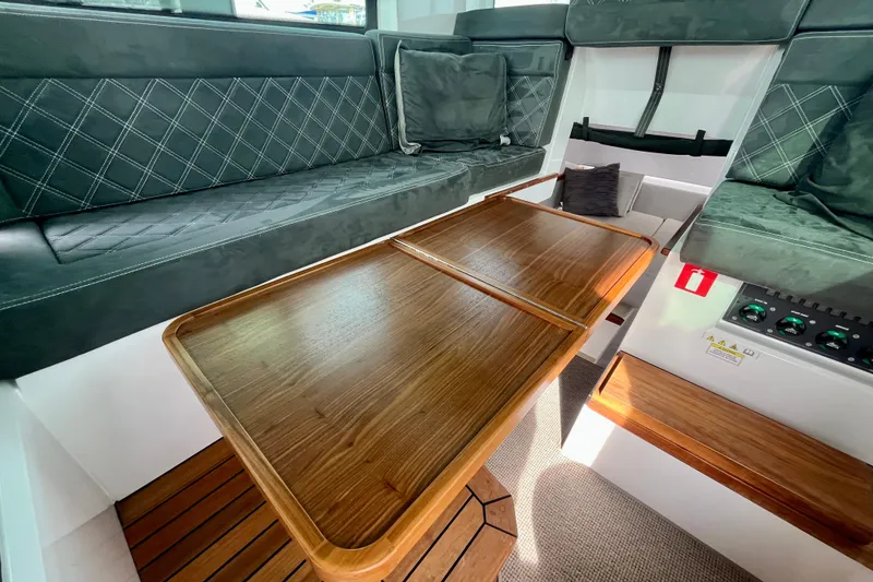 Slide: The Image of Luxurious interior of 2018 Axopar 37 Sport Cabin R with wooden table and cushioned seating. - 22