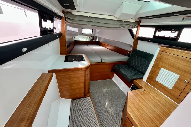 Slide: The Image of 2018 Axopar 37 Sport Cabin R interior with wood accents and cozy seating area. - 27