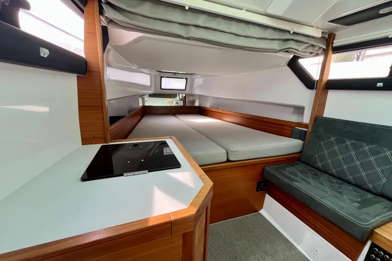 Slide: The Image of Interior of 2018 Axopar 37 Sport Cabin R, featuring cozy seating and a compact kitchenette. - 28