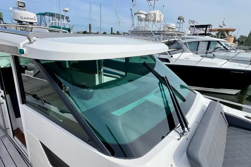 Slide: The Image of 2018 Axopar 37 Sport Cabin R boat docked with sleek design and windshield wipers. - 34