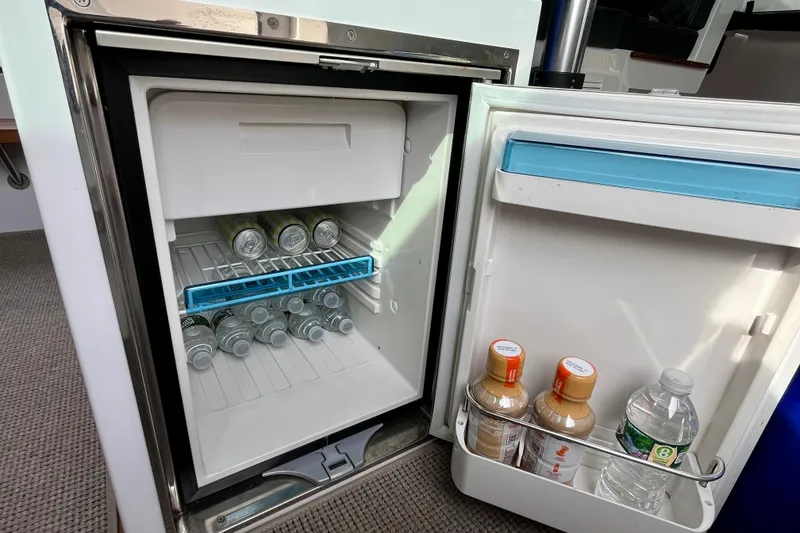 Slide: The Image of Mini fridge stocked with drinks inside a 2018 Axopar 37 Sport Cabin R boat. - 36