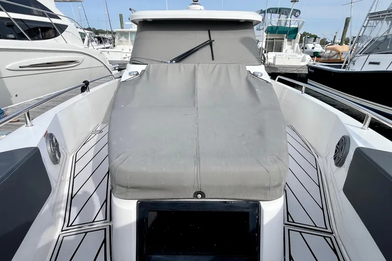 Slide: The Image of 2018 Axopar 37 Sport Cabin R boat with covered deck, docked among other vessels. - 43