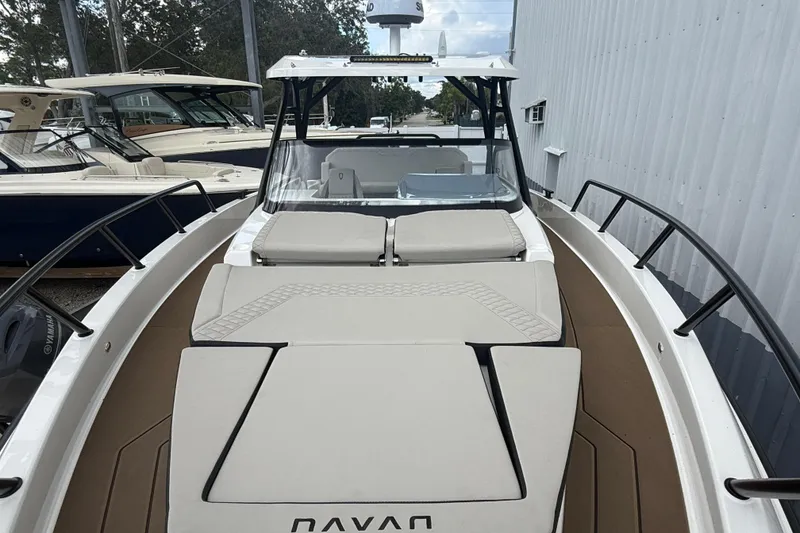 Slide: The Image of 2026 Navan S30 boat with cushioned deck, docked alongside other vessels. - 19