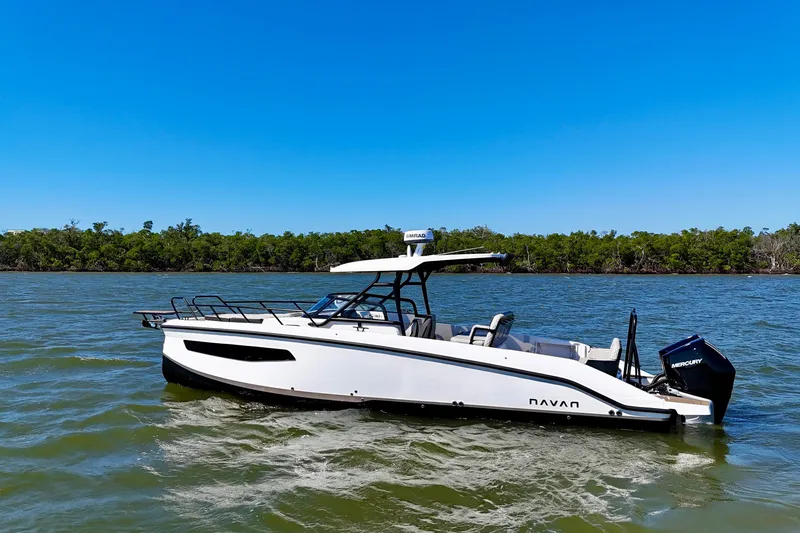 Slide: The Image of Navan S30 boat 2026 on calm water near wooded shoreline. - 2
