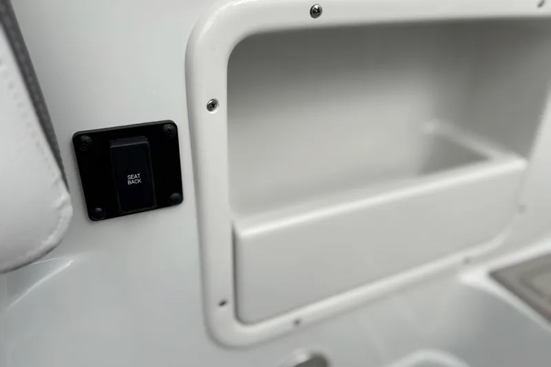 Slide: The Image of 2026 Crownline 260 XSS boat interior with seat back switch and storage compartment. - 16
