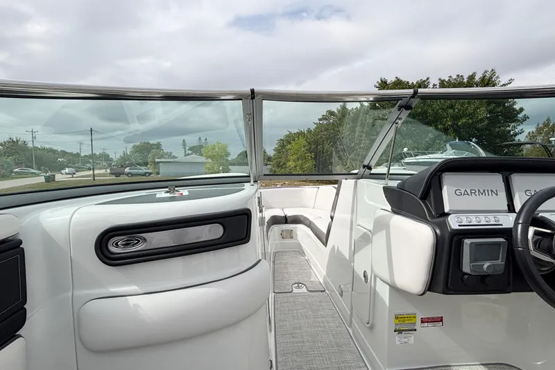 Slide: The Image of 2026 Crownline 260 XSS boat interior with Garmin navigation system, sleek white seating, and modern dashboard. - 19