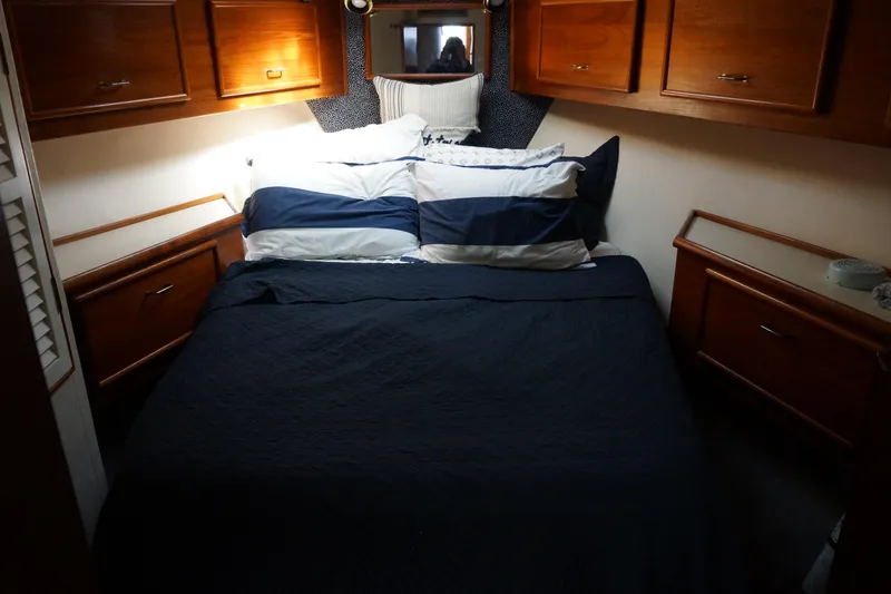 Slide: The Image of Cozy bedroom in 1988 Ocean Yachts Super Sport with wooden cabinets and striped bedding. - 13