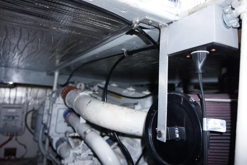 Slide: The Image of Engine room of 1988 Ocean Yachts Super Sport, showcasing mechanical components and piping. - 16