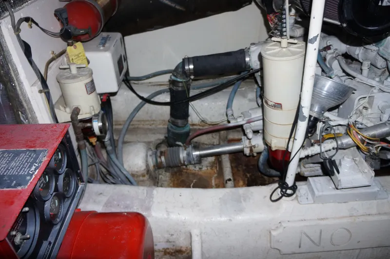 Slide: The Image of Engine room of 1988 Ocean Yachts Super Sport, showcasing mechanical components and wiring. - 17