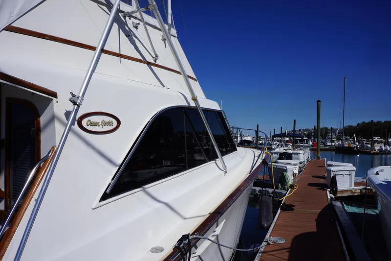 Slide: The Image of 1988 Ocean Yachts Super Sport docked at a marina under clear blue skies. - 4