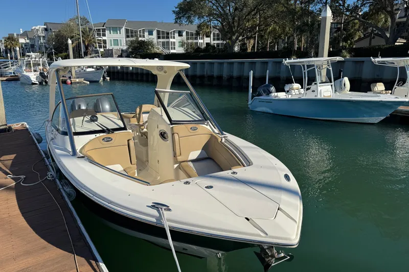 Slide: The Image of 2015 Scout 275 Dorado boat docked in a marina under clear blue skies. - 1
