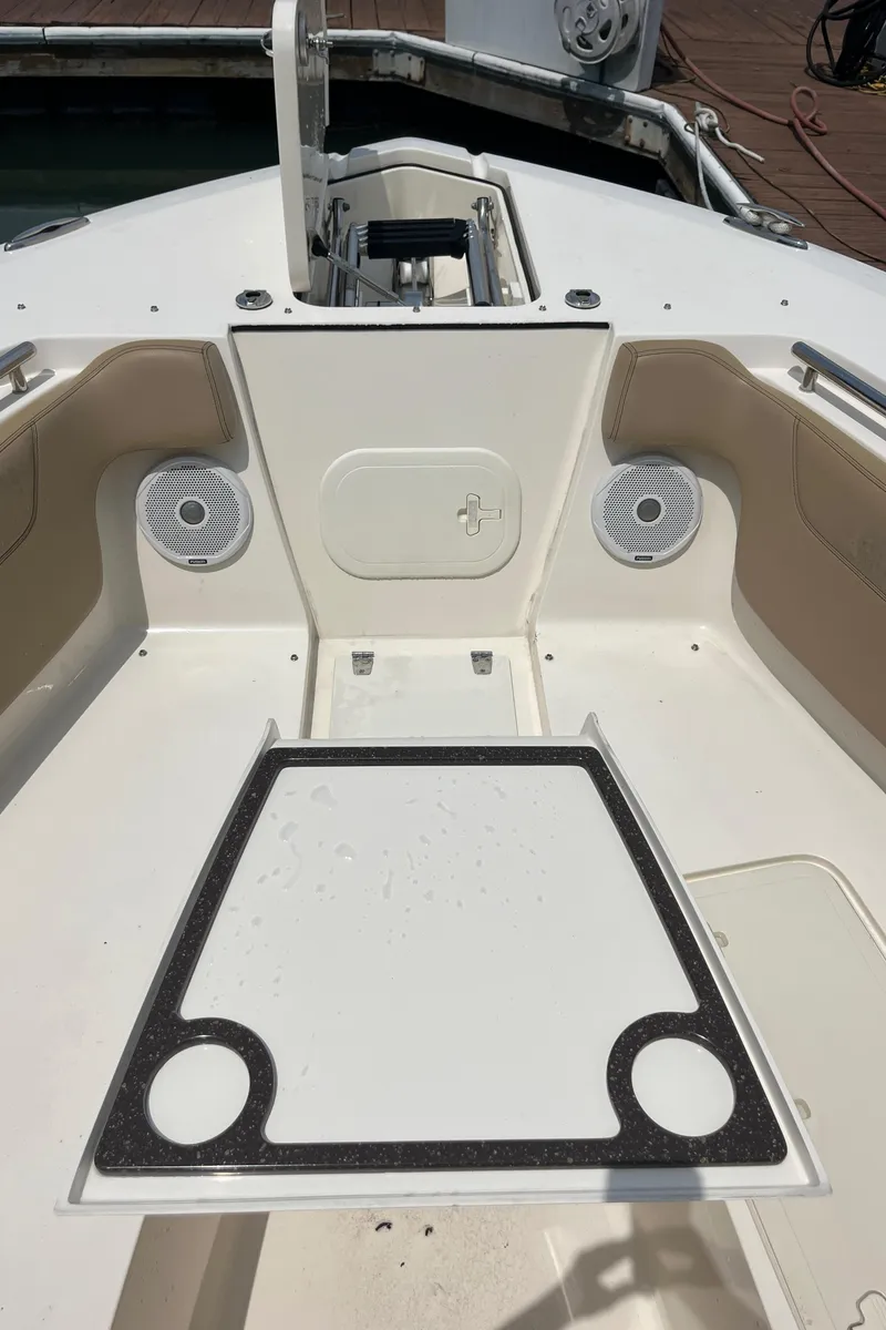 Slide: The Image of Interior view of 2015 Scout 275 Dorado boat with ceiling light and marina background. - 34