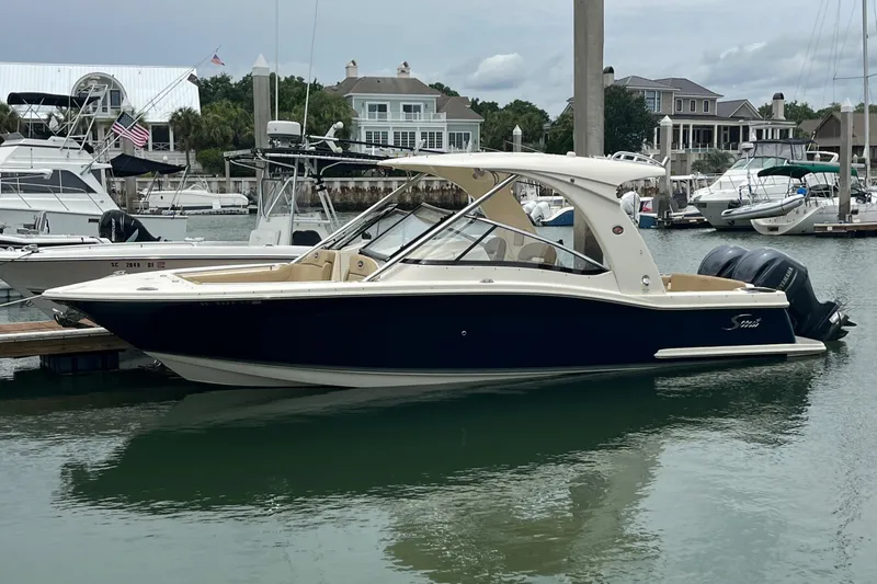 Slide: The Image of 2015 Scout 275 Dorado boat with beige seating, docked in calm waters. - 5