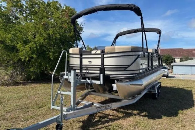Slide: The Image of 2026 Starcraft EXS 3 DL pontoon boat on trailer, parked on grass. - 3