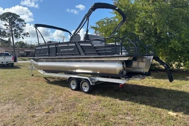 Slide: The Image of 2026 Starcraft EXS 3 Q DH pontoon boat on trailer, parked on grass. - 7