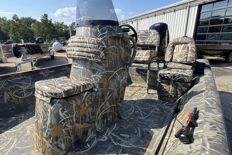 Slide: The Image of 2026 War Eagle 961 Blackhawk boat with camouflage design, parked outdoors. - 14