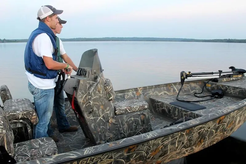 Slide: The Image of Two people on a 2026 War Eagle 961 Blackhawk boat on a calm lake. - 16