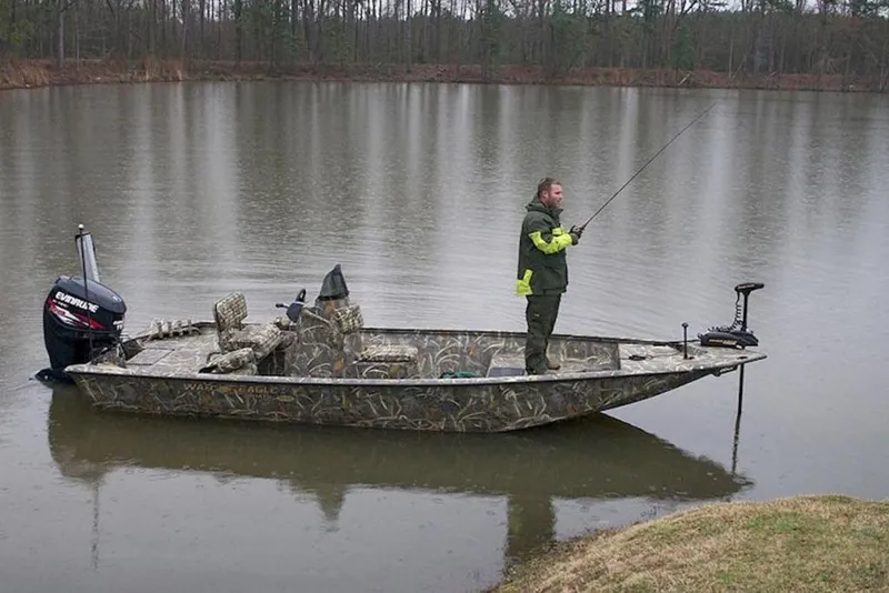 Slide: The Image of Man fishing on a 2026 War Eagle 961 Blackhawk boat in a calm lake. - 20