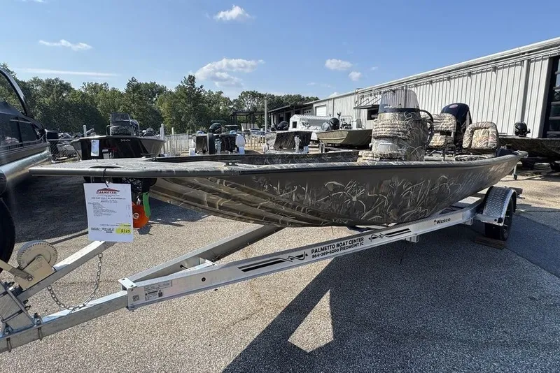 Slide: The Image of 2026 War Eagle 961 Blackhawk boat on trailer, camo design, outdoor display. - 8