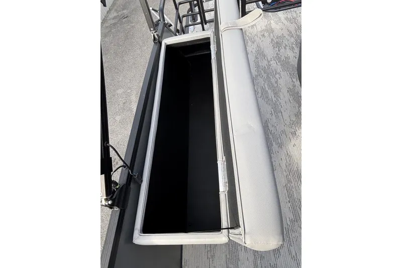 Slide: The Image of Open storage compartment on 2026 Starcraft EXS 1 Q DH boat, featuring cushioned seating. - 18