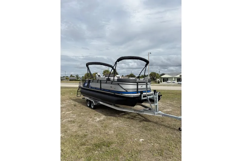Slide: The Image of 2026 Starcraft SLS 3 Q DH pontoon boat on trailer, parked outdoors. - 3