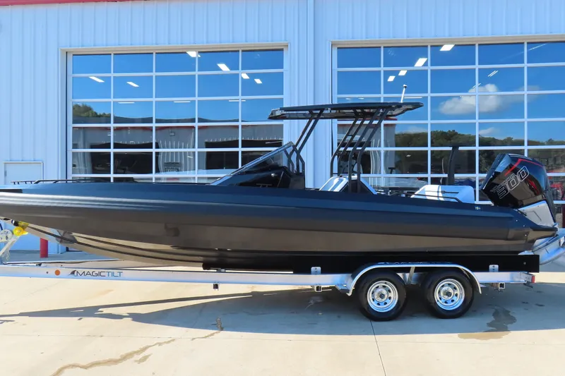 Slide: The Image of 2026 Iron 767 boat on trailer, sleek black design, parked outside large glass building. - 27