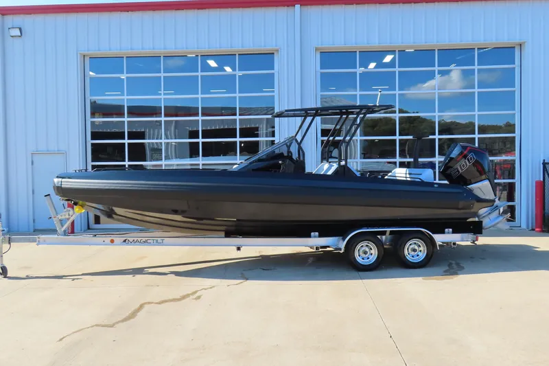 Slide: The Image of Black Iron 767 boat on trailer, parked outside a modern building, 2026 model. - 28