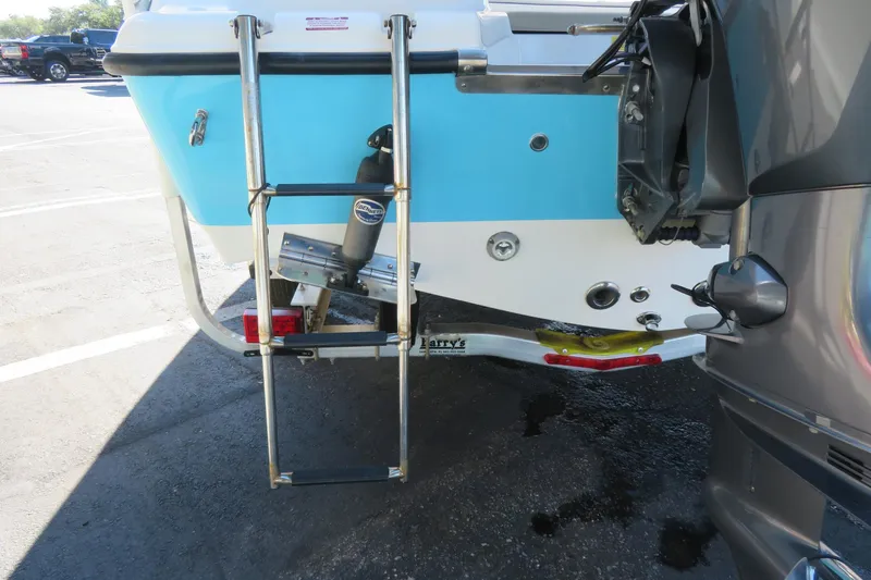 Slide: The Image of 2022 Key West 189 FS boat rear view with ladder and motor in parking lot. - 11