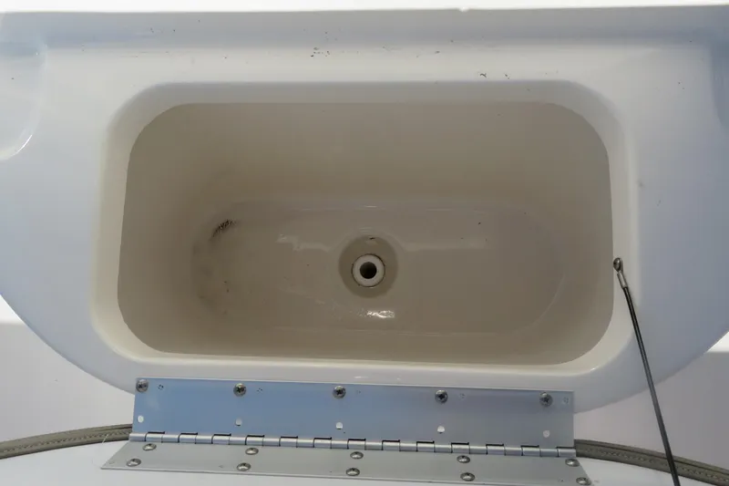 Slide: The Image of Livewell compartment in 2022 Key West 189 FS boat, featuring a drain and hinge. - 20
