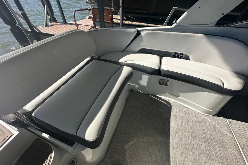 Slide: The Image of 2023 Crownline 290 CR boat interior with gray seating and waterfront view. - 12