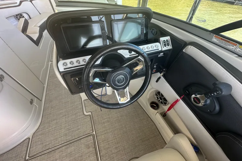 Slide: The Image of 2023 Crownline 290 CR boat helm with steering wheel and dual displays. - 23