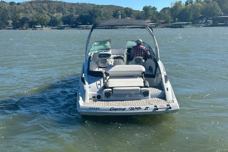 Slide: The Image of 2023 Crownline 290 CR boat cruising on a lake with scenic shoreline. - 38