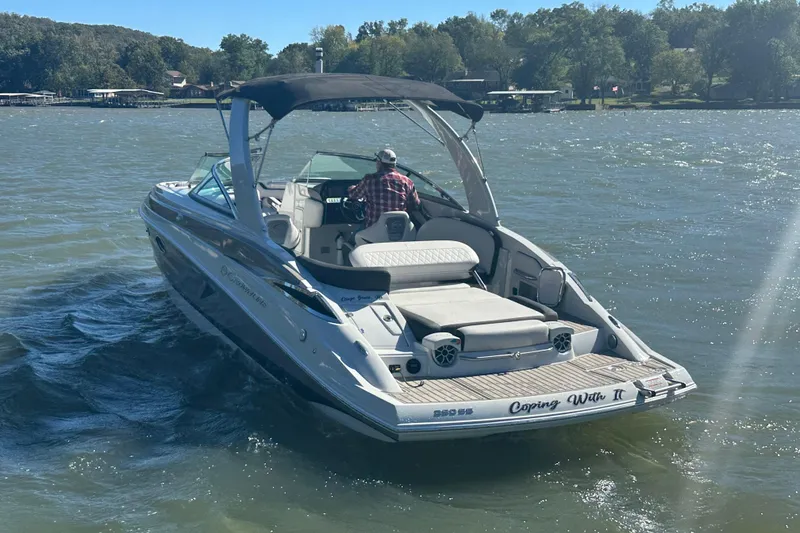 Slide: The Image of 2023 Crownline 290 CR boat cruising on a lake with lush green shoreline. - 39