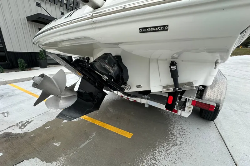 Slide: The Image of 2023 Crownline 290 CR boat on trailer, showcasing propeller and stern details. - 54
